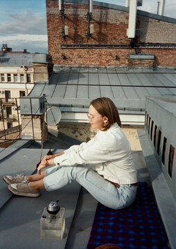Young Woman Enjoying the Rooftop View on a Sunny Day with hookah