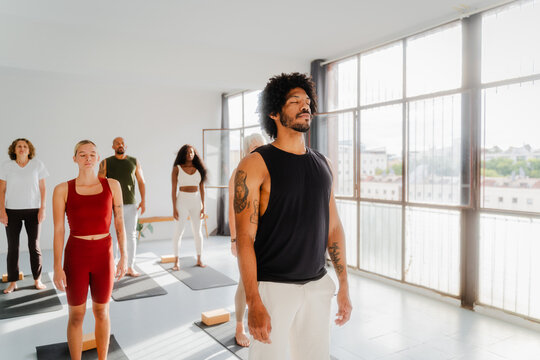 Group of people practice yoga with an instructor
