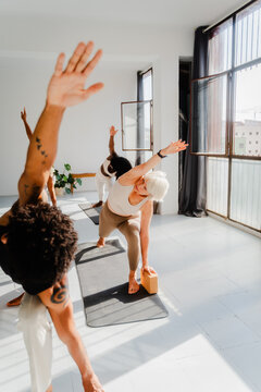Group of people practice yoga with an instructor