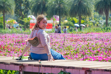 Woman Sitting on Wooden Path in Flower Field
