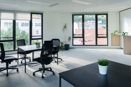 Bright and Spacious Office Featuring Black Chairs and Tables