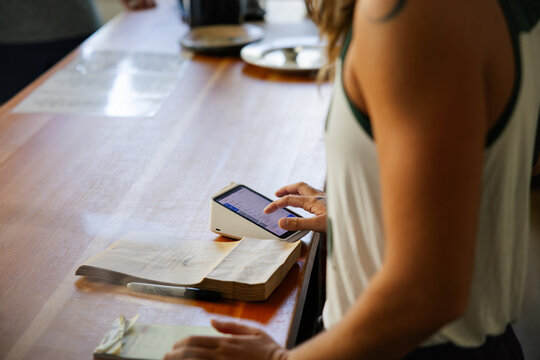 Person using smartphone at wooden counter