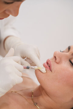 Woman receiving lip filler injection for cosmetic beauty treatment
