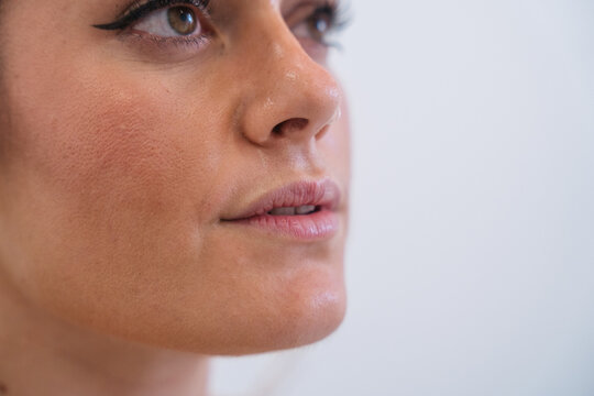 Woman with natural skin texture and subtle makeup looking up