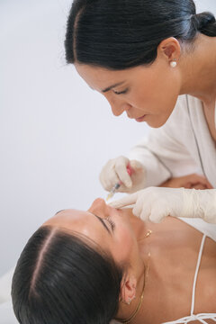 Woman getting cosmetic lip filler injection procedure
