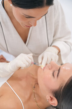 Doctor injecting lip filler on patient for beauty treatment