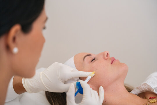 Woman receiving cosmetic anti-aging dermal filler injection