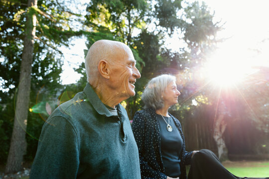 Smiling elderly couple enjoying sunshine in a garden setting