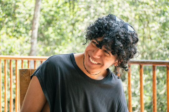 Smiling Young Man Enjoys Nature in a Wooded Area During Daytime