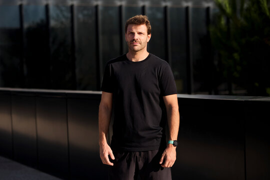 Man in black shirt standing outdoors for training