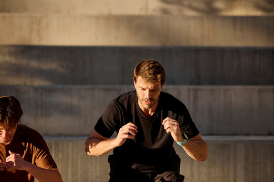 Outdoor squat jump exercise with trainer and client