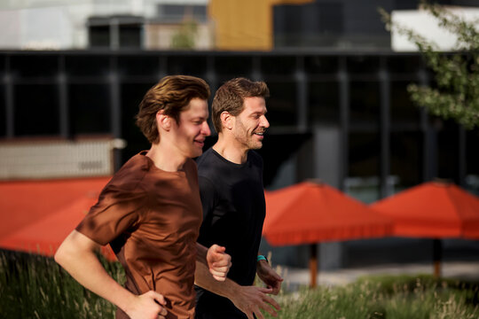 Two men jogging side by side during workout