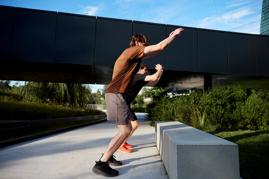 Man performing knee drive exercise outdoors