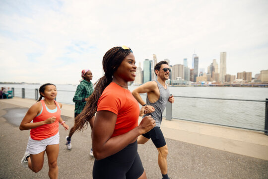 Athletes run along the East river bank