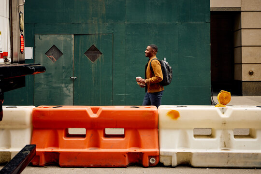Man walks down the street wearing backpack