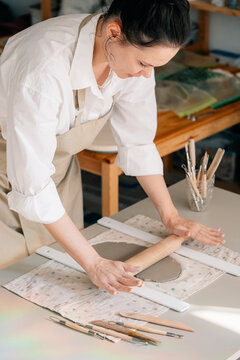 Woman Crafting Pottery on a Table in a Studio Setting