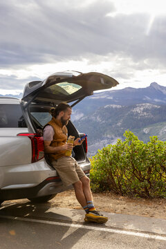Hiker smartphone rest at car Road trip Yosemite National Park 