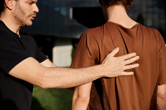 Trainer correcting client&rsquo;s posture during workout