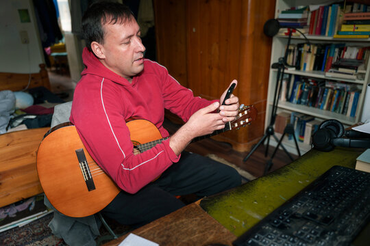 Musician Plays Guitar While Checking Phone
