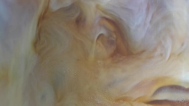4K Milk swirling into coffee abstract marble patterns Close up beverage background with creamy texture, minimal cafe concept and soft liquid motion.