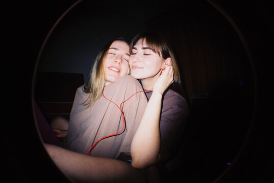 Shared Music Joy: Two Women with Headphones
