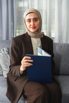 Confident Muslim Woman Working from Home with a Folder