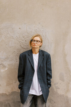 Stylish Woman Poses Confidently Against a Textured Wall