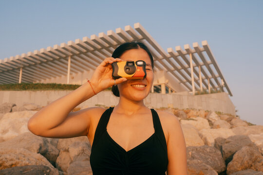 Woman taking a photo with a disposable camera
