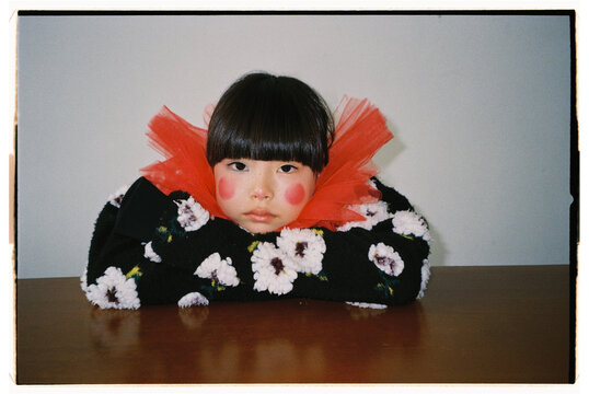 Young girl with a playful expression wearing colorful clothing