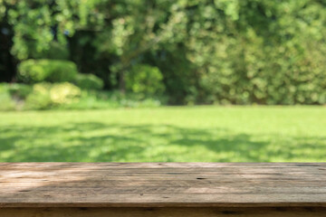 Empty wood table top with abstract blur park garden background