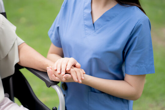 Close up nurse holding hand senior patient for encourage, assistance and support, caregiver touch hand elderly woman with empathy and comfort, rehabilitation therapy mental health for elderly.