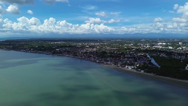 Aerial view of rural coastal neighborhood in Iloilo City Philippines featuring small houses near tropical shoreline. Authentic local community landscape along the urban edge of Panay Island.