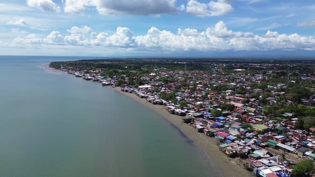 Aerial view of rural coastal neighborhood in Iloilo City Philippines featuring small houses near tropical shoreline. Authentic local community landscape along the urban edge of Panay Island.