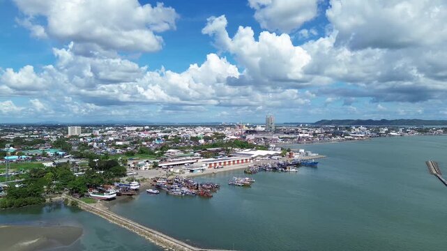 Aerial view of Iloilo City showing tropical coastline and urban skyline under dramatic clouds. Harbor with Anchored Boats, Coastal development and vibrant Philippine city atmosphere from above.