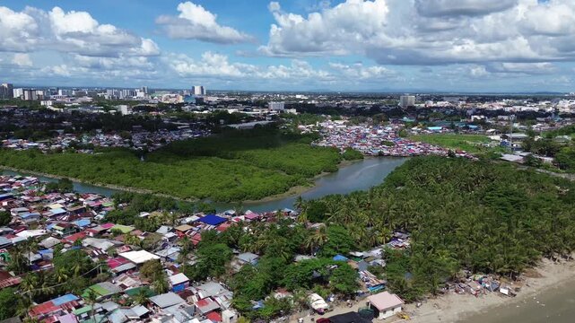 Drone aerial of Iloilo City highlighting modern skyline, residential districts, Rural Areas with River, and expanding infrastructure on Panay Island. Dynamic urban growth in the central Philippines.