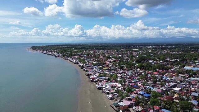 Aerial view of rural coastal neighborhood in Iloilo City Philippines featuring small houses near tropical shoreline. Authentic local community landscape along the urban edge of Panay Island.