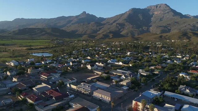 Low flyover of Ladismith South Africa toward mountains at edge of town