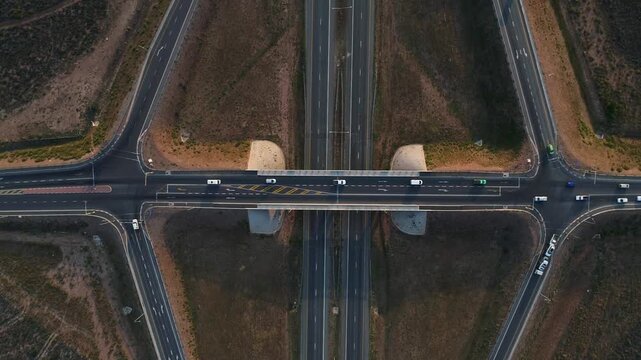 Aerial looks down on vehicle traffic driving on highway interchange