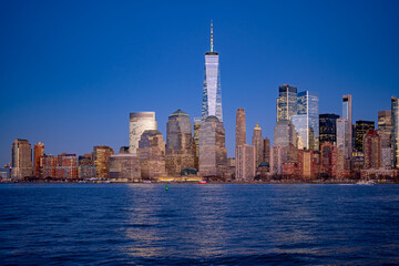 Obraz premium Manhattan cityscape over waterfront. NYC skyline scenic river view. New York City skyline iconic panorama. Manhattan skyline photography scene. NYC skyline modern American city.