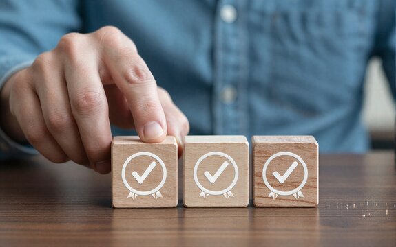 Hand places checkmark on wooden blocks symbolizing approval or