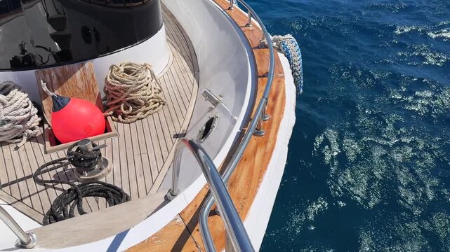 Top view of yacht stern deck with mooring lines and buoy during anchoring procedure at sea