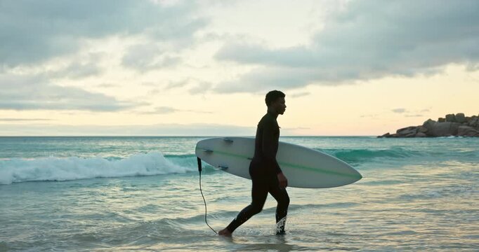 Walking, waves and man on beach with surfboard for water sports, adventure and active hobby on holiday. Surfer, nature and person done with surfing activity in ocean on vacation, break and weekend