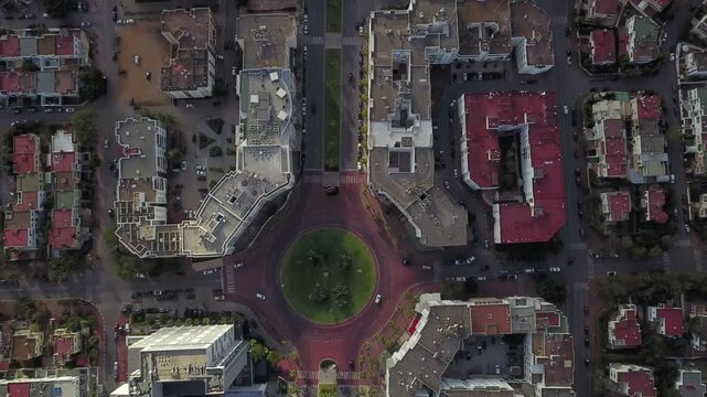 Aerial drone shot capturing the flow of traffic on a major avenue in Hay Riad. Highlights the modern architecture, green medians, and the vibrant business atmosphere of Rabat city center.