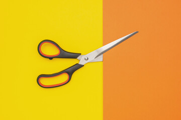 Scissors on Vibrant Yellow and Orange Background Highlighting Creativity and Precision