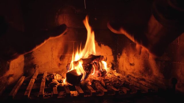 A Man Warming His Hands By The Fire From The Fireplace
