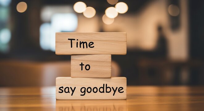 A wooden block sign on a table that reads time to say goodbye