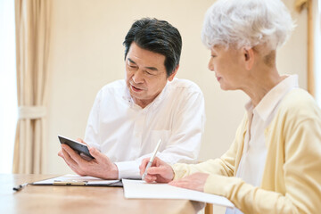 Fototapeta premium 家計の計算をするアジア人シニア夫婦