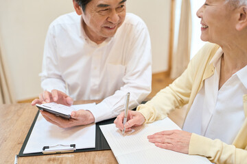 Obraz premium 家計の計算をするアジア人シニア夫婦