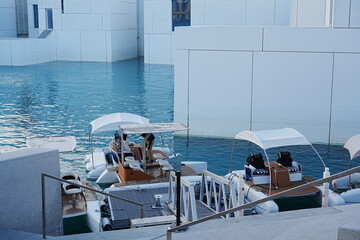 Fototapeta premium A stunning exterior view of the Louvre Abu Dhabi shows its floating dome shimmering above calm waterfront reflections.