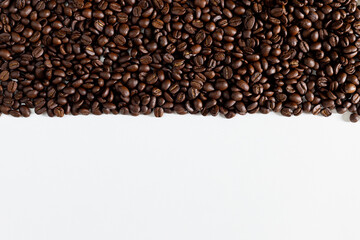 Fototapeta premium Top view of a roasted coffee beans, against a white background